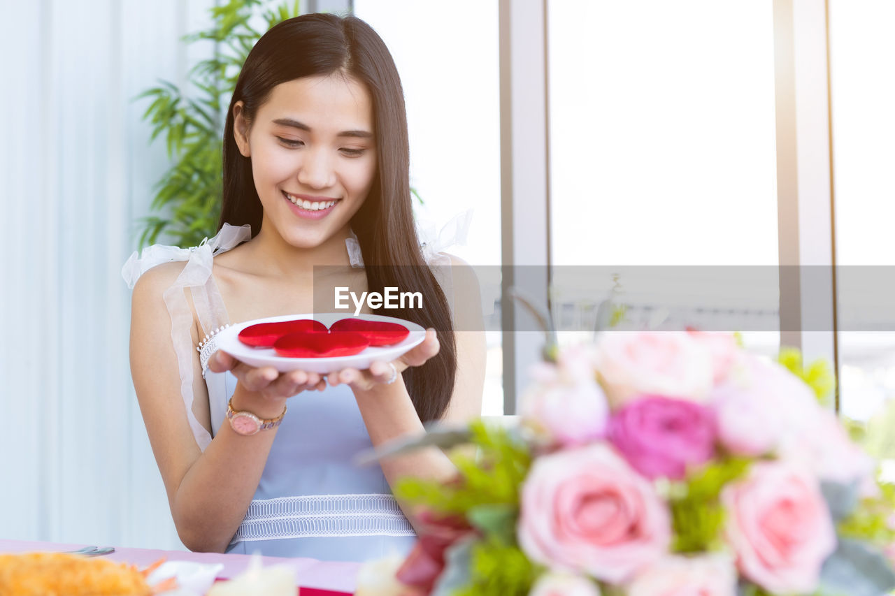 WOMAN HOLDING RED ROSE IN HAND