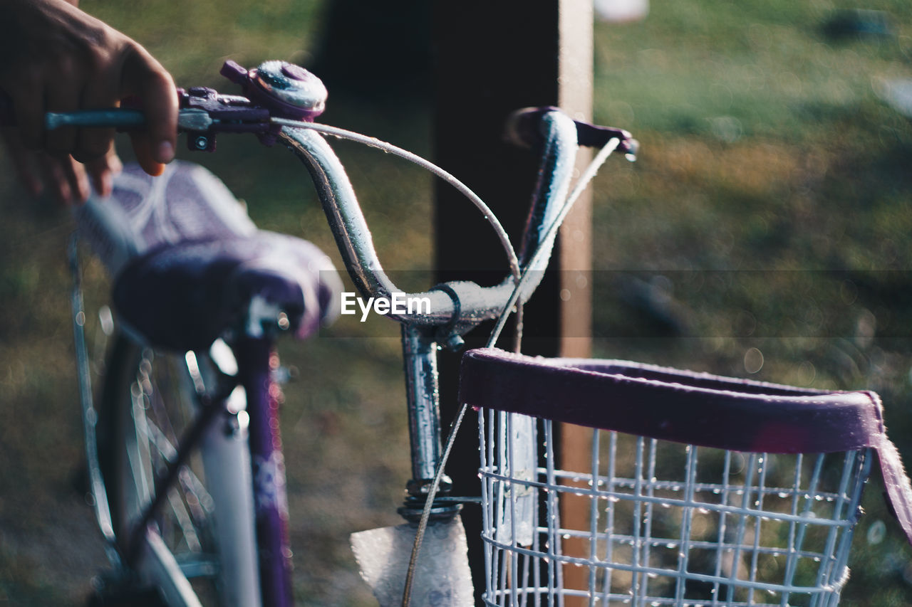 Cropped hand of woman holding bicycle