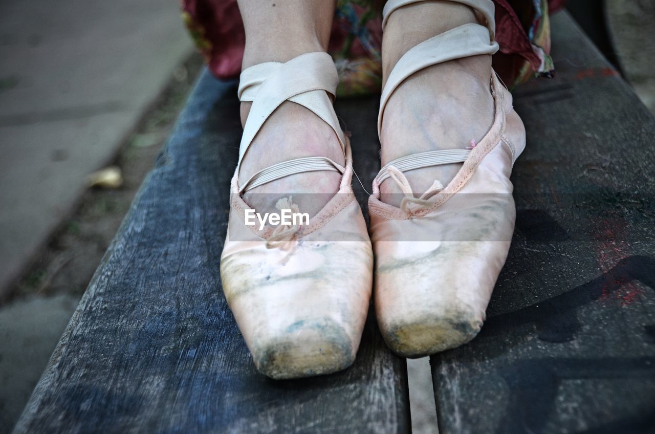 Low section of ballet dancer in show sitting on table