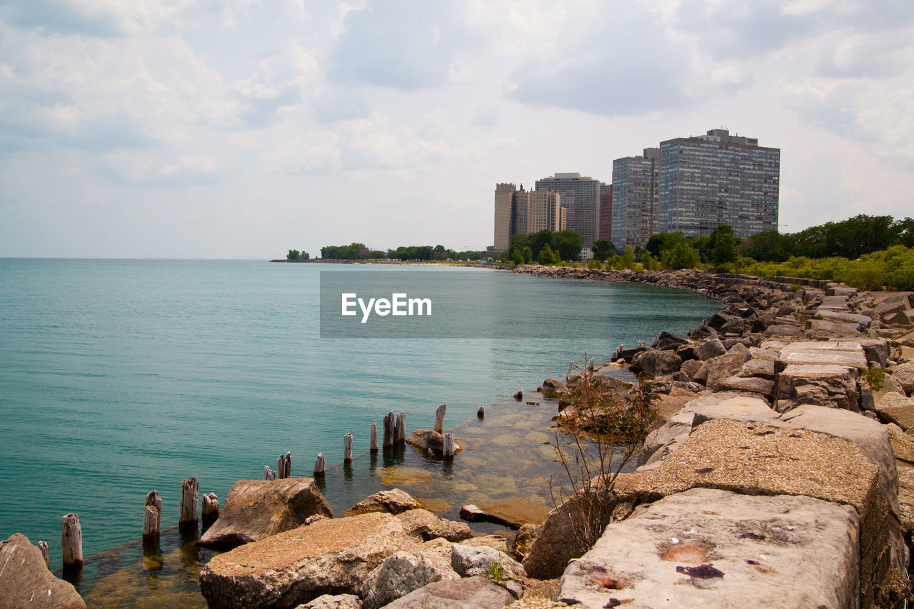 scenic view of sea by buildings against sky