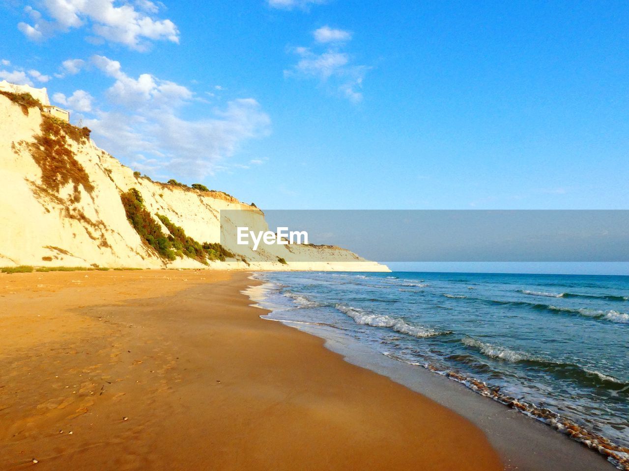 scenic view of beach against blue sky