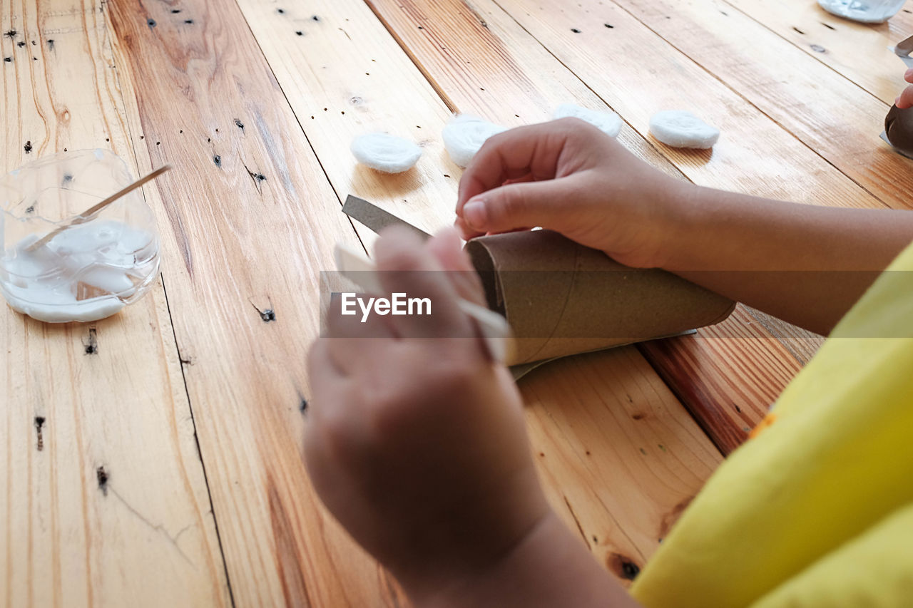 HIGH ANGLE VIEW OF WOMAN HAND ON CUTTING BOARD