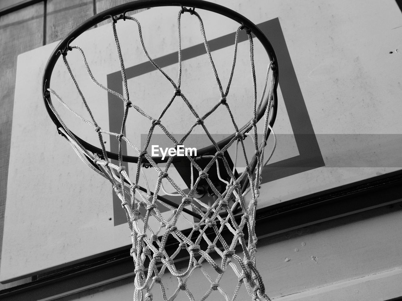 LOW ANGLE VIEW OF BASKETBALL HOOP AGAINST WALL