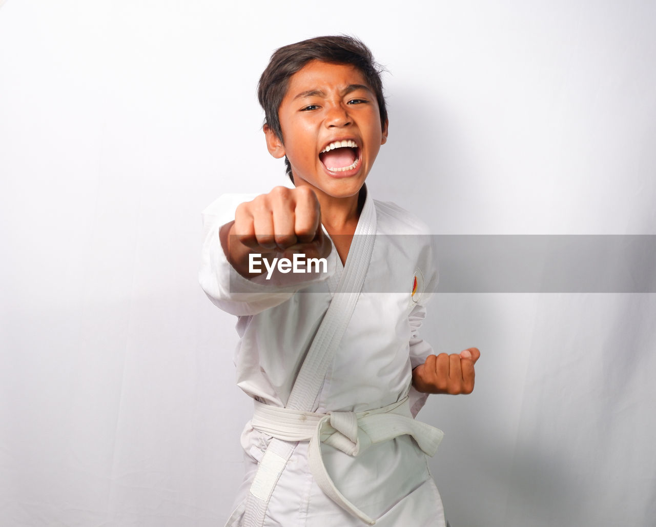 A child is demonstrating a martial arts punch