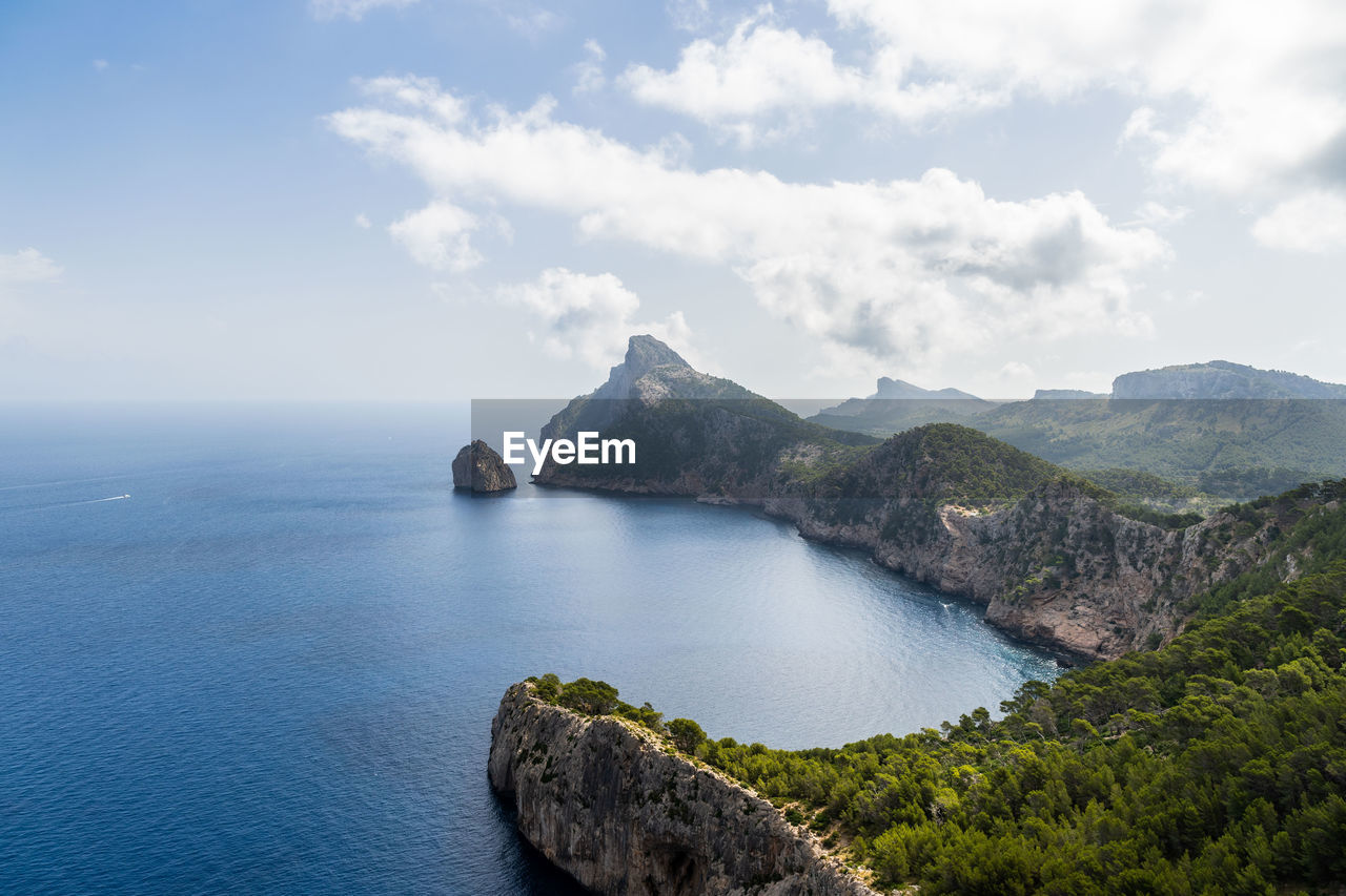 scenic view of sea by mountains against sky