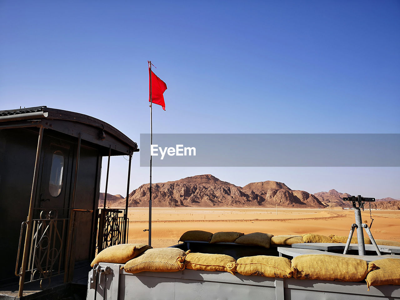 Flag on an old train at the wadi rum station in the desert against clear blue sky