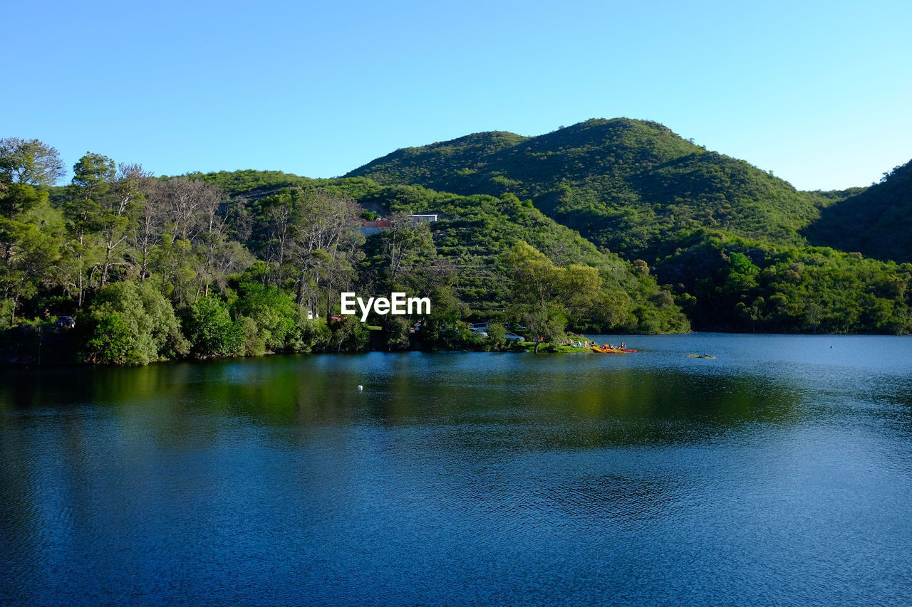 Scenic view of lake against clear blue sky