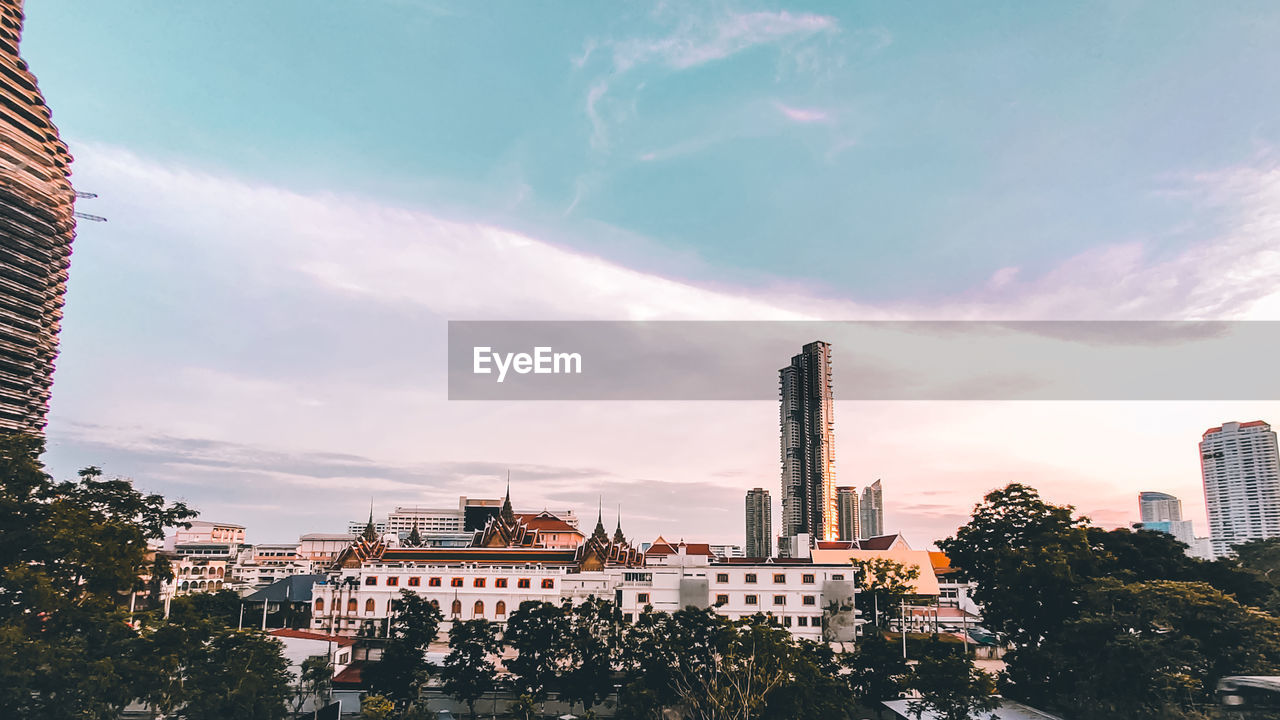 Buildings in city against cloudy sky