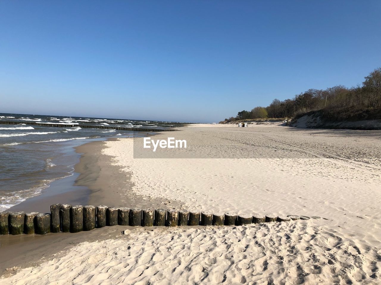 SURFACE LEVEL OF SANDY BEACH AGAINST CLEAR BLUE SKY