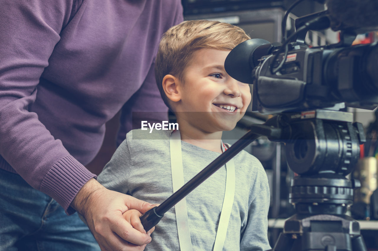 Boy with grandfather using television camera