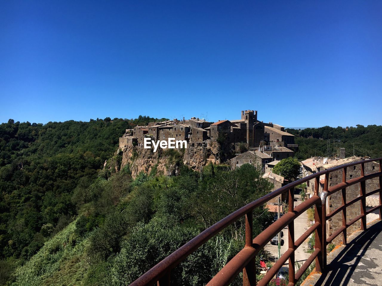 Built structure on landscape against clear blue sky