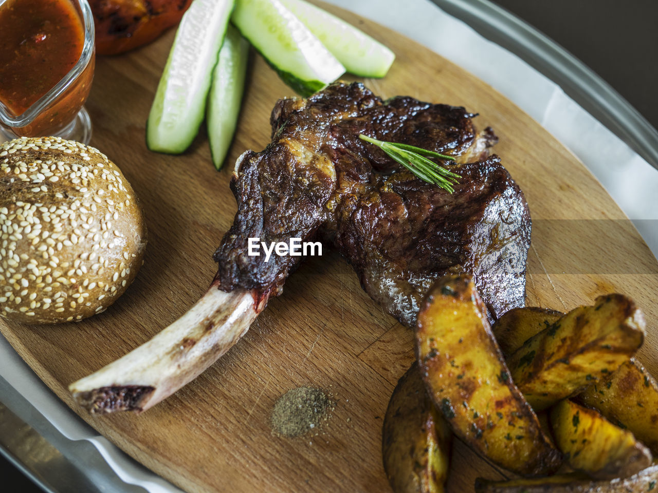 Close-up of grilled chicken with burger and french fries on cutting board