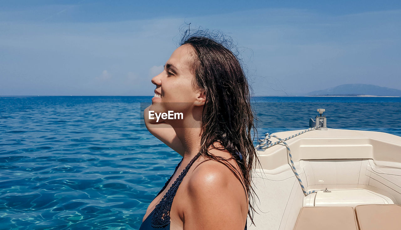 Woman sunbathing on boat at sea.