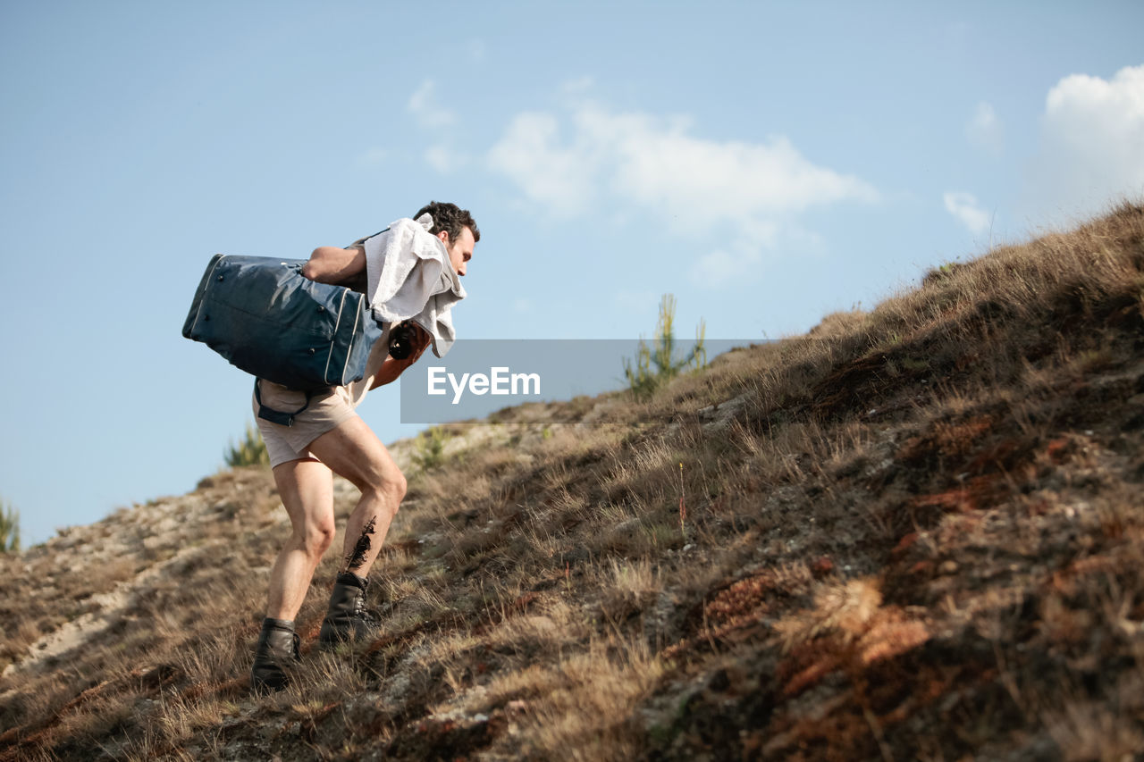 Low angle view of man climbing a hill