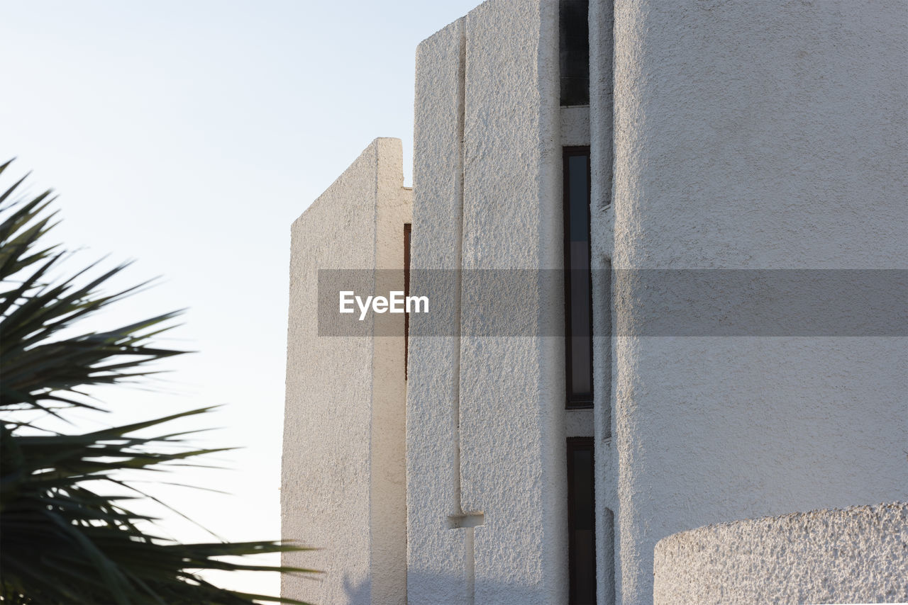 LOW ANGLE VIEW OF BUILDING WALL AGAINST SKY