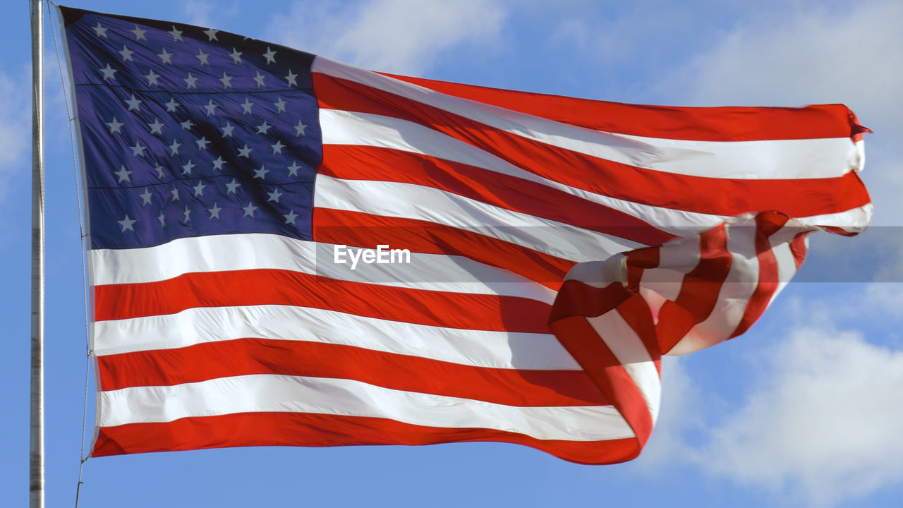 American usa flag on a flagpole waving in the wind. close up of american flag waving.