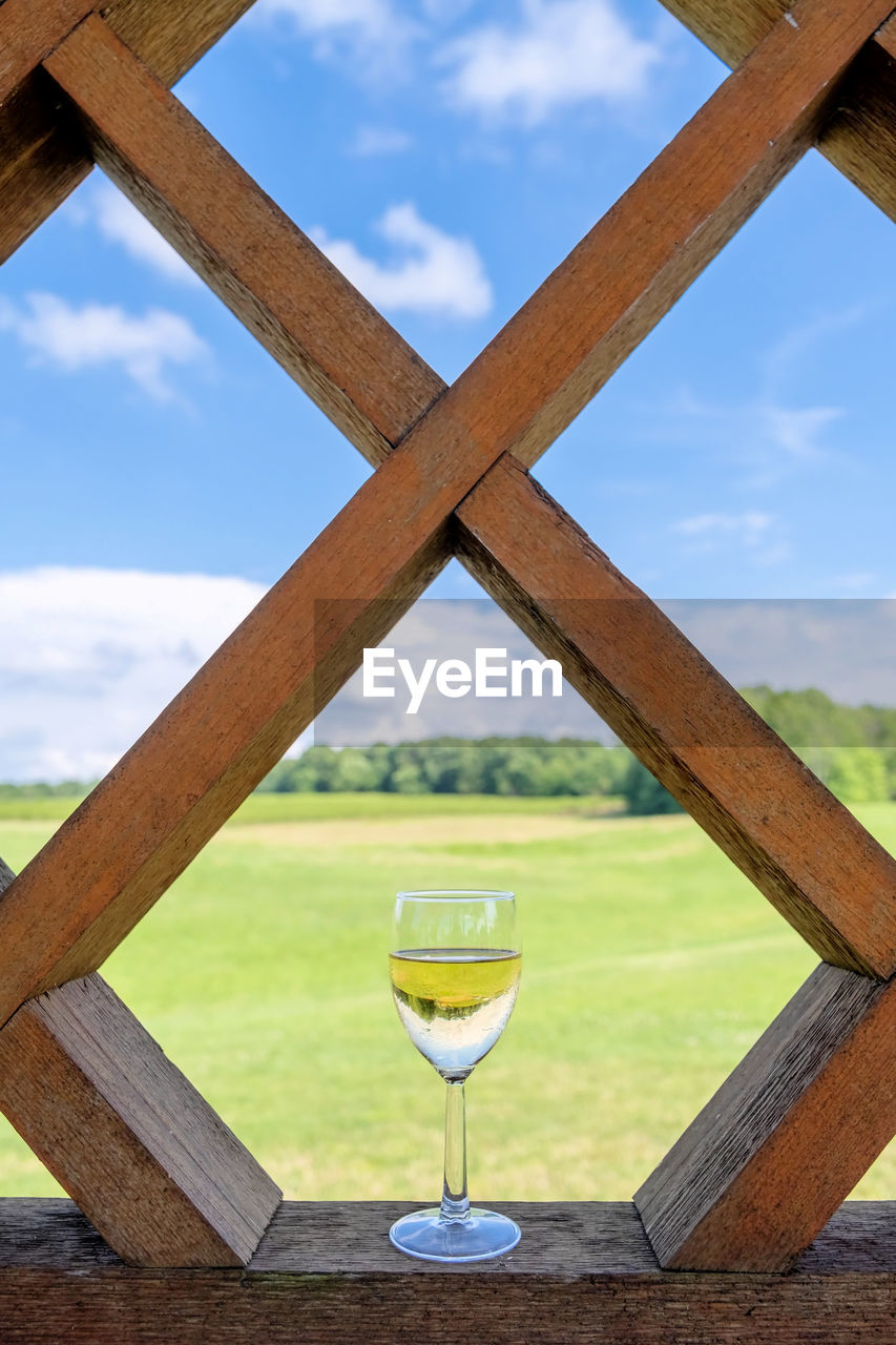 Close-up of wine glass on table against sky