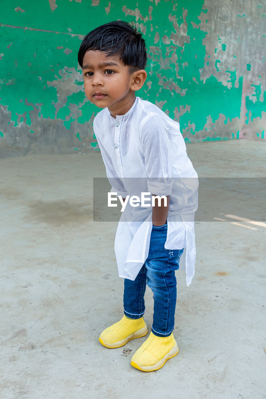 BOY STANDING AGAINST WALL