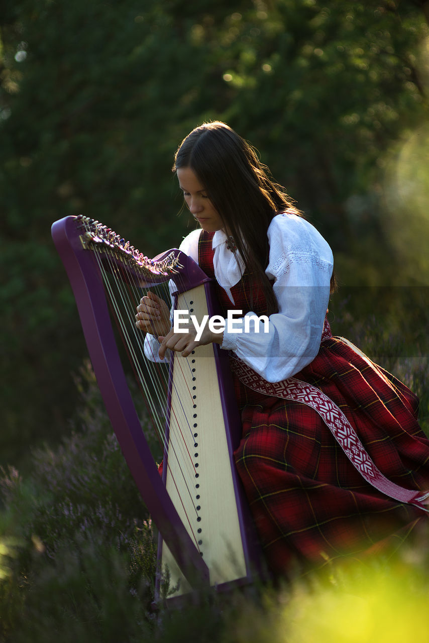 Woman playing harp outdoors