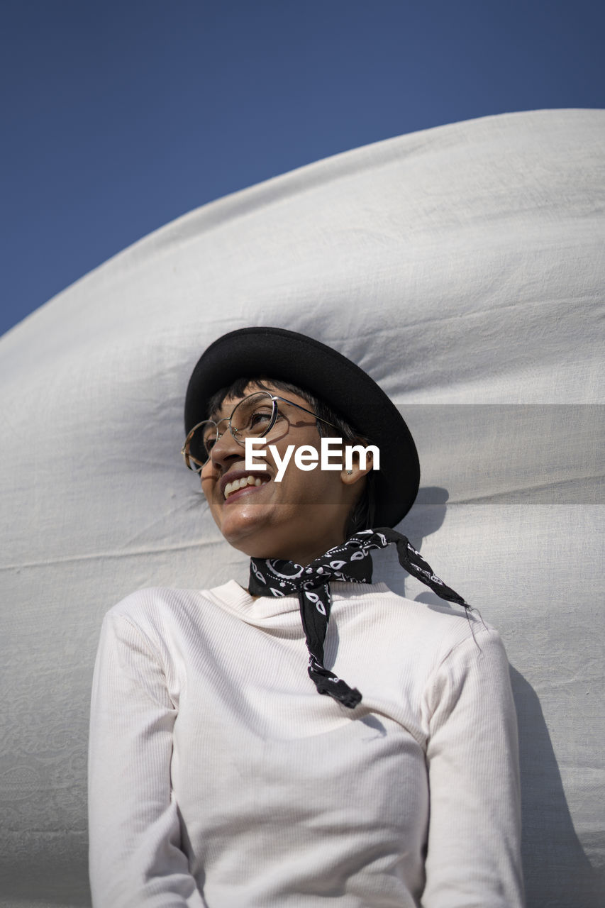 Smiling woman looking away against sky