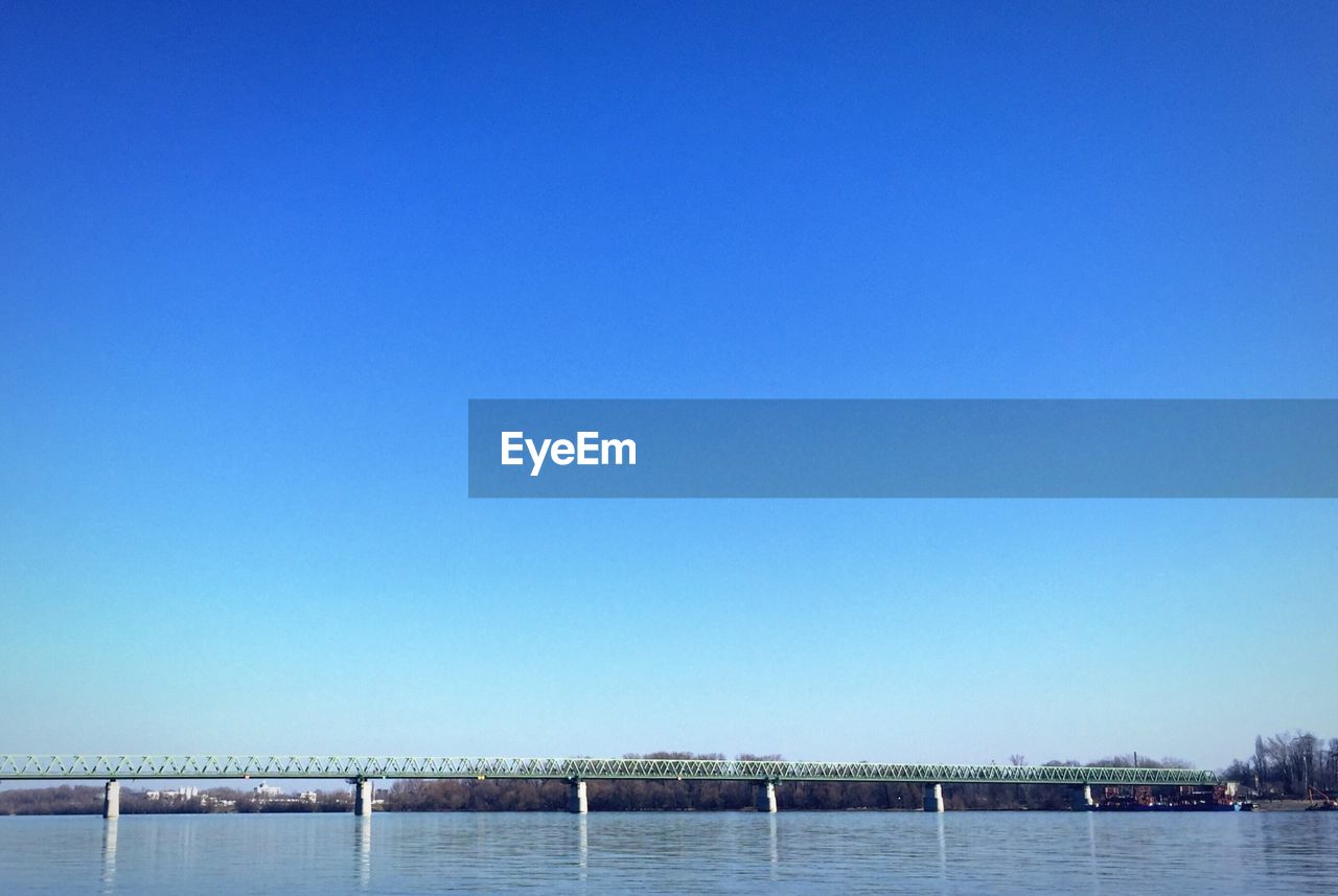 Bridge crossing over river against clear sky