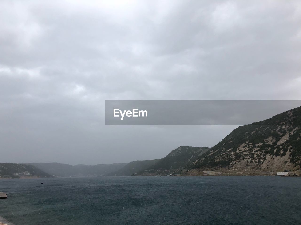 SCENIC VIEW OF SEA BY MOUNTAINS AGAINST SKY