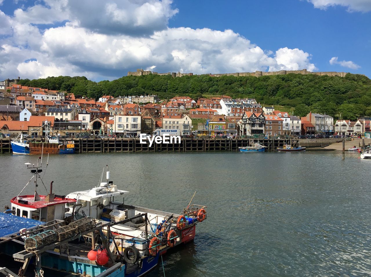 HIGH ANGLE VIEW OF TOWNSCAPE BY LAKE AGAINST SKY