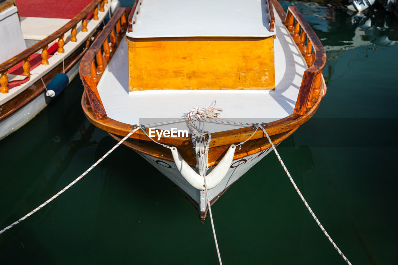 Wooden side of the boat, painted white and brown, with a beautiful wooden fence 