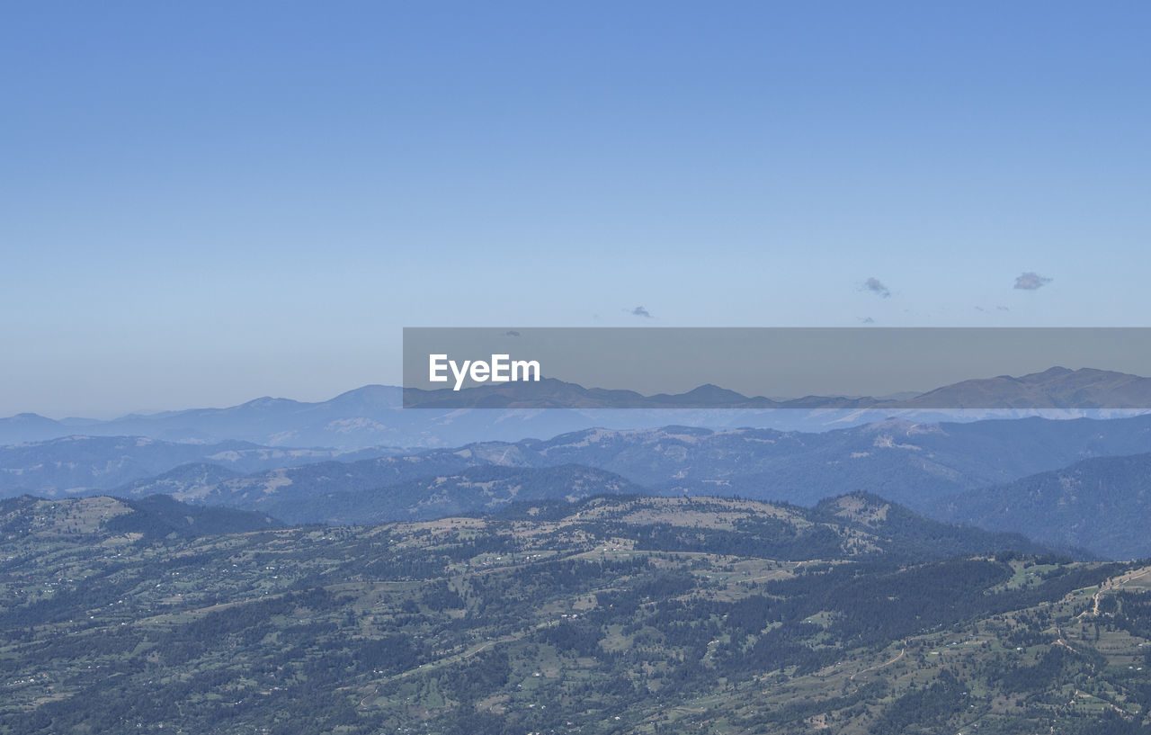 Scenic view of mountains against clear blue sky