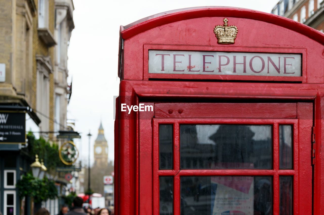 Text on red telephone booth in city