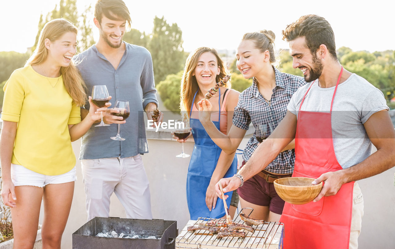 Friends enjoying meat and wine at social gathering