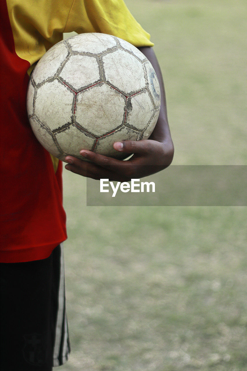 Footballer standing with a ball in hand in kolkata.