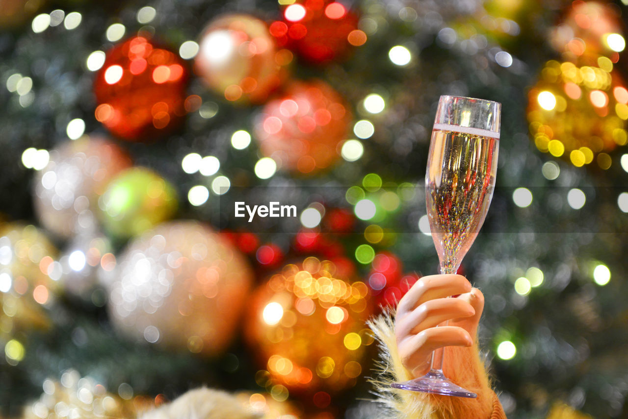 CLOSE-UP OF WOMAN'S HAND HOLDING CHRISTMAS TREE