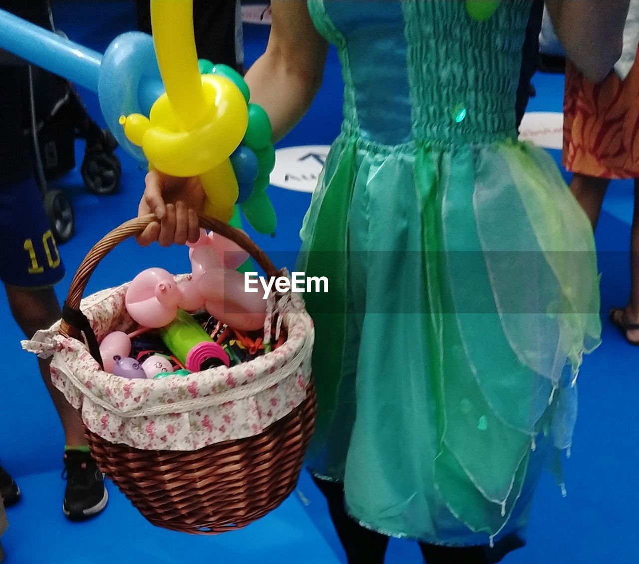 MIDSECTION OF WOMAN HOLDING ICE CREAM CONE IN BASKET