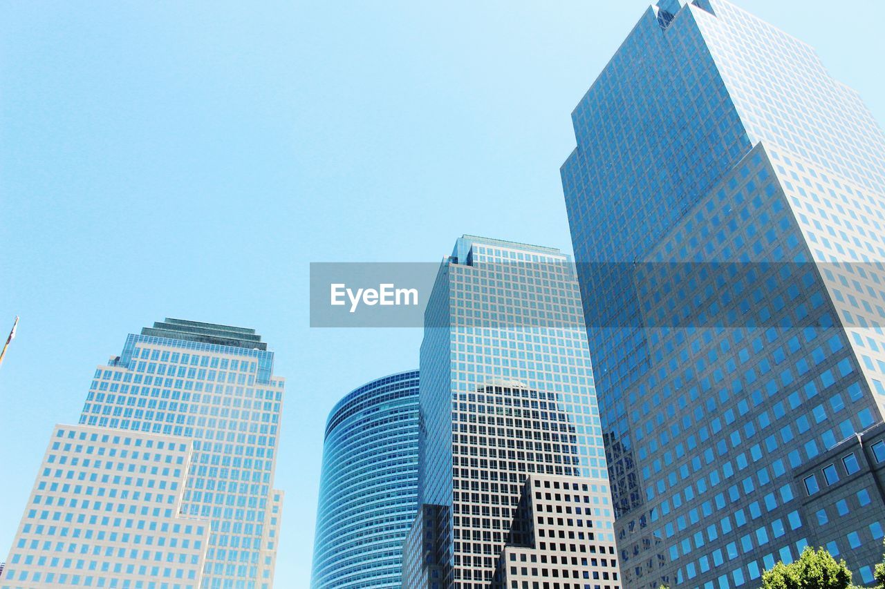 Low angle view of modern buildings against clear blue sky