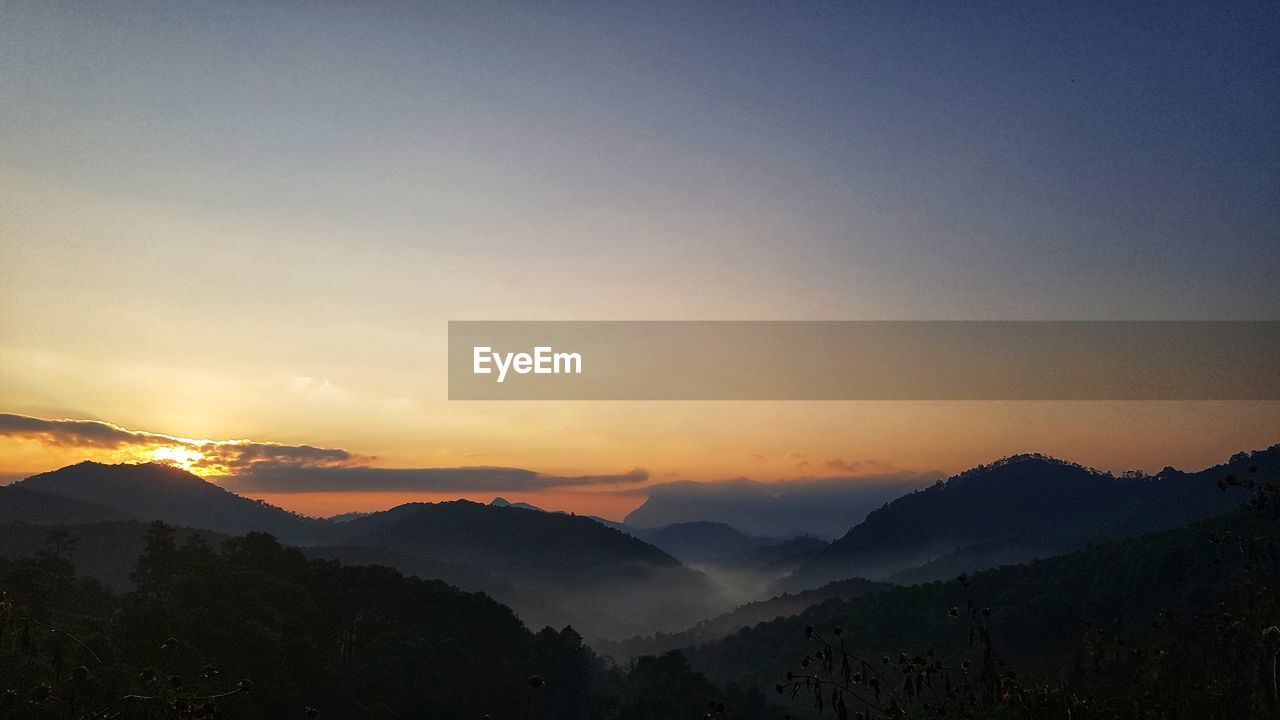 Scenic view of silhouette mountains against sky during sunset