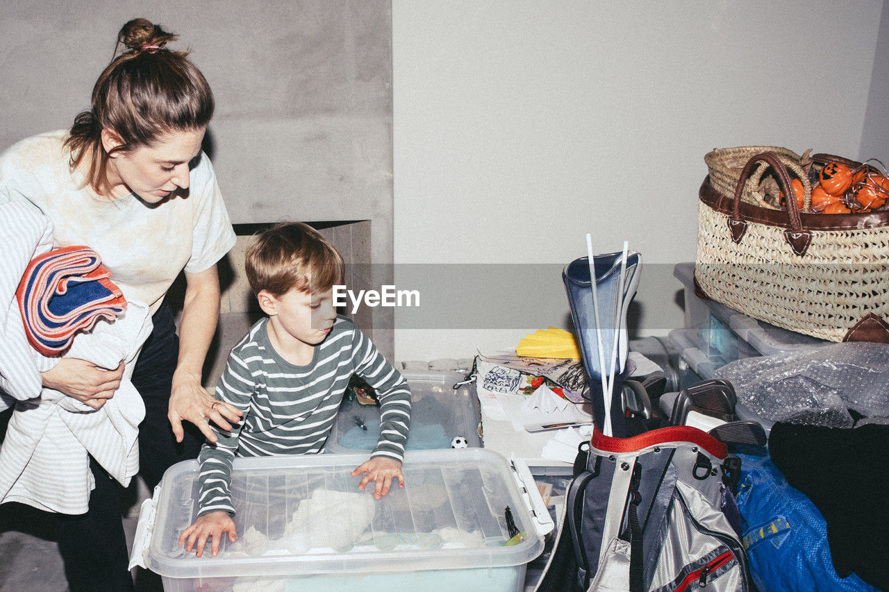 High angle view of son helping mother during relocation of house