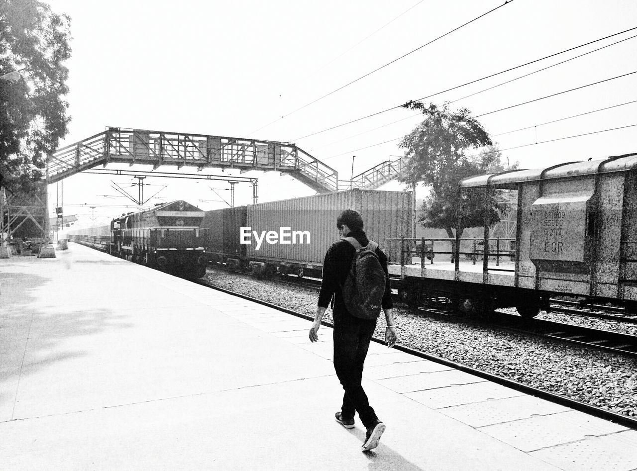 MAN WALKING ON WET ROAD IN CITY