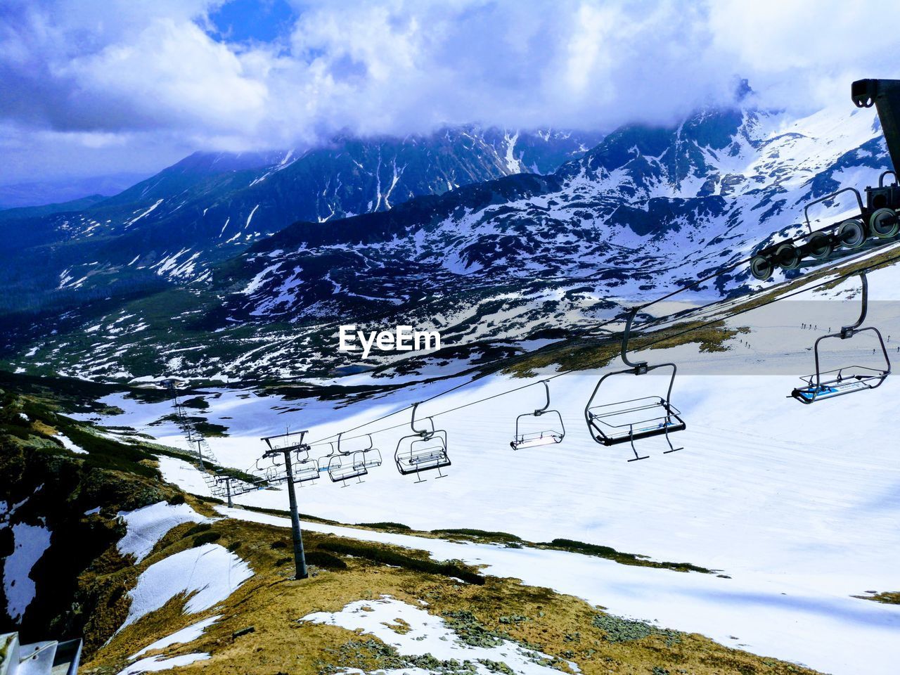 AERIAL VIEW OF SNOW COVERED MOUNTAINS AGAINST SKY