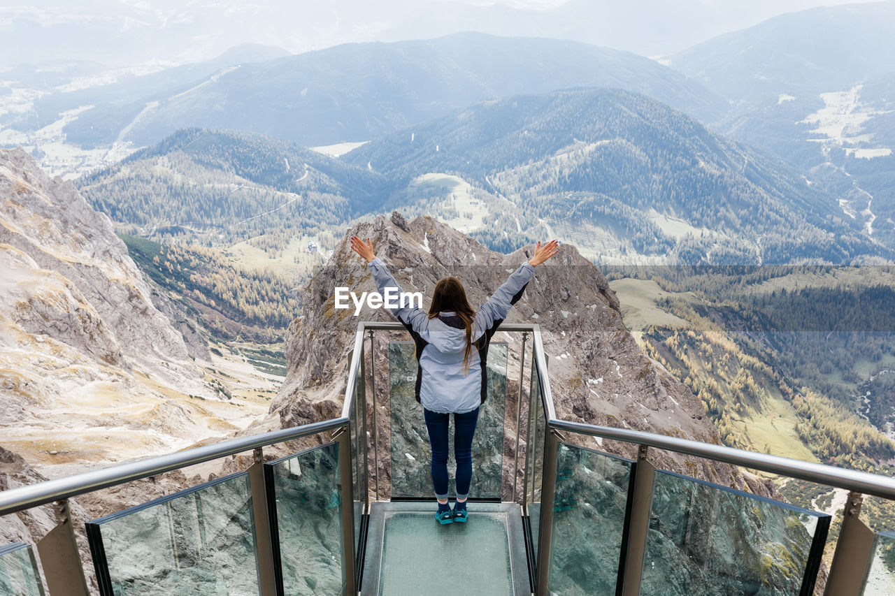 Millennial girl enjoys the views of alps from the observation deck