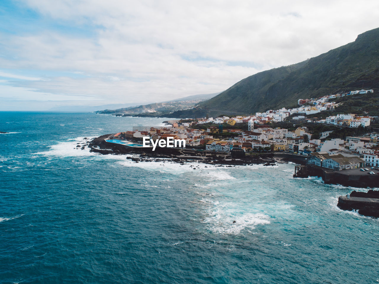 Scenic view of sea by buildings against sky