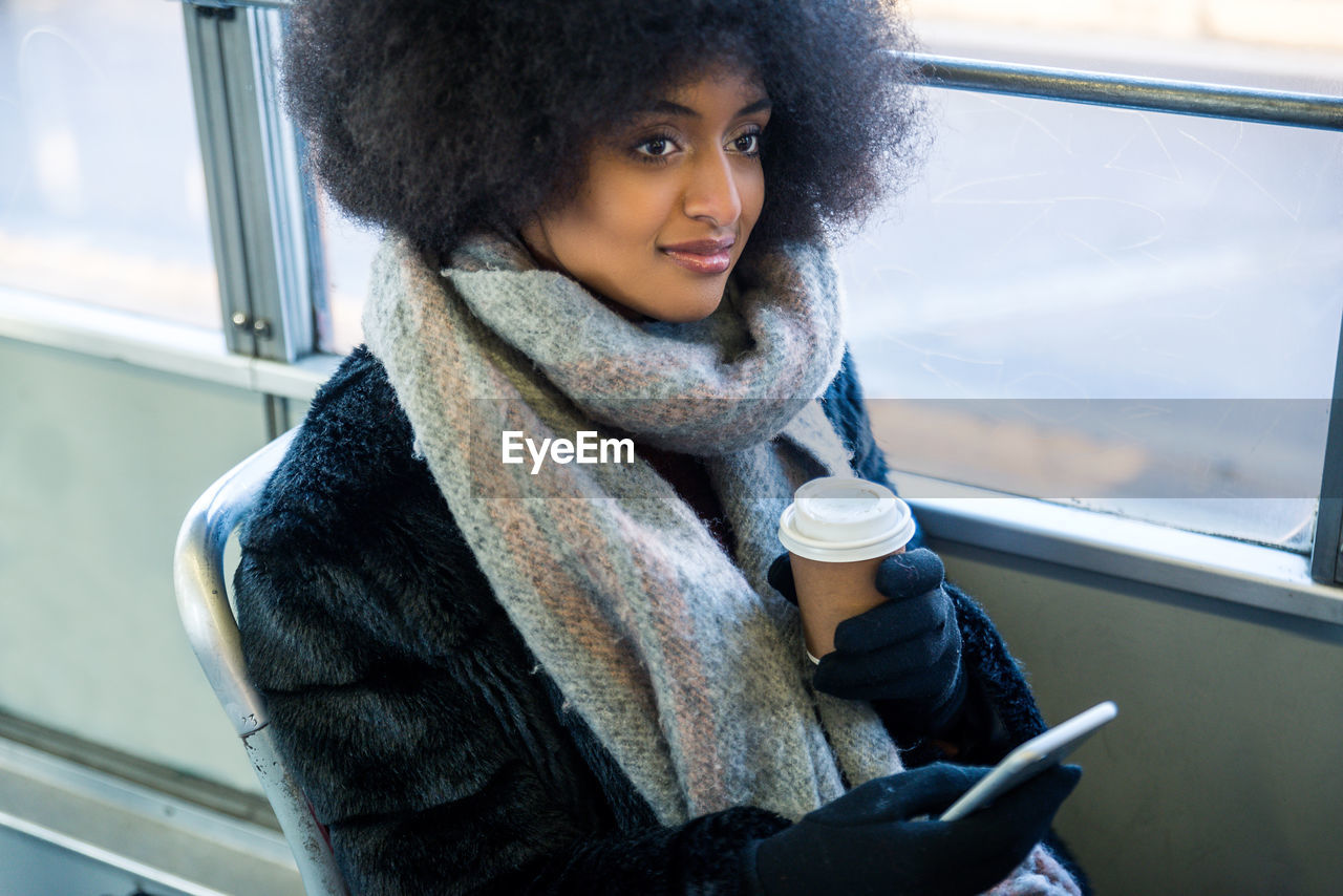 YOUNG WOMAN DRINKING COFFEE AT BUS