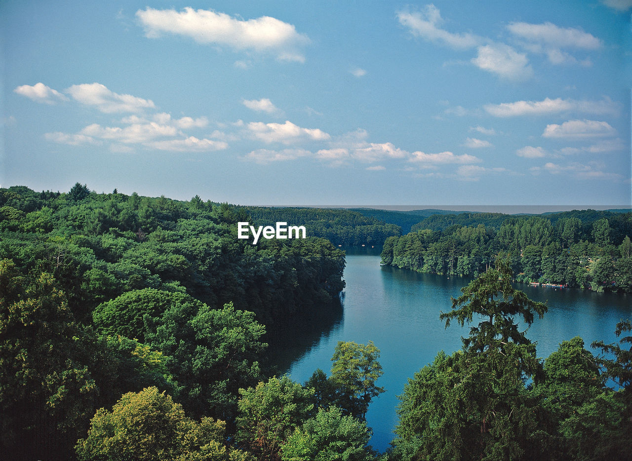 High angle view of trees by calm river against sky