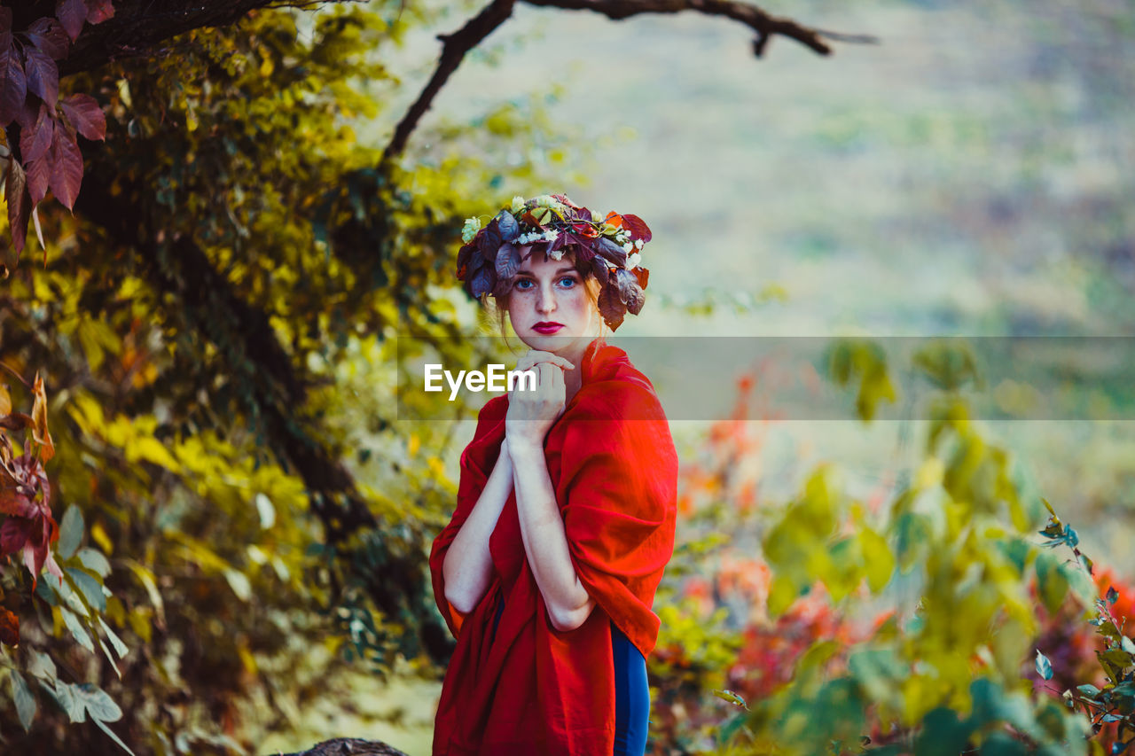Midsection of woman with red leaves