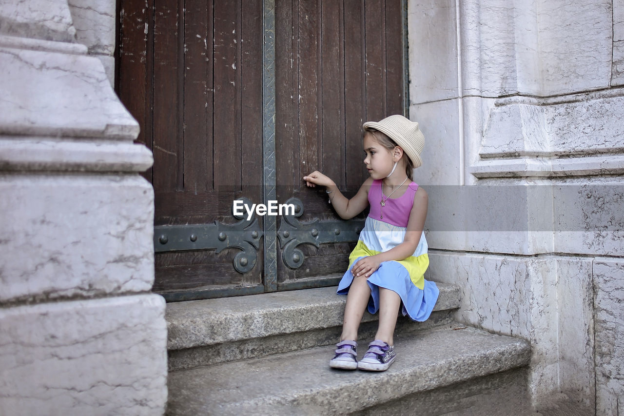 Girl touching door while on staircase