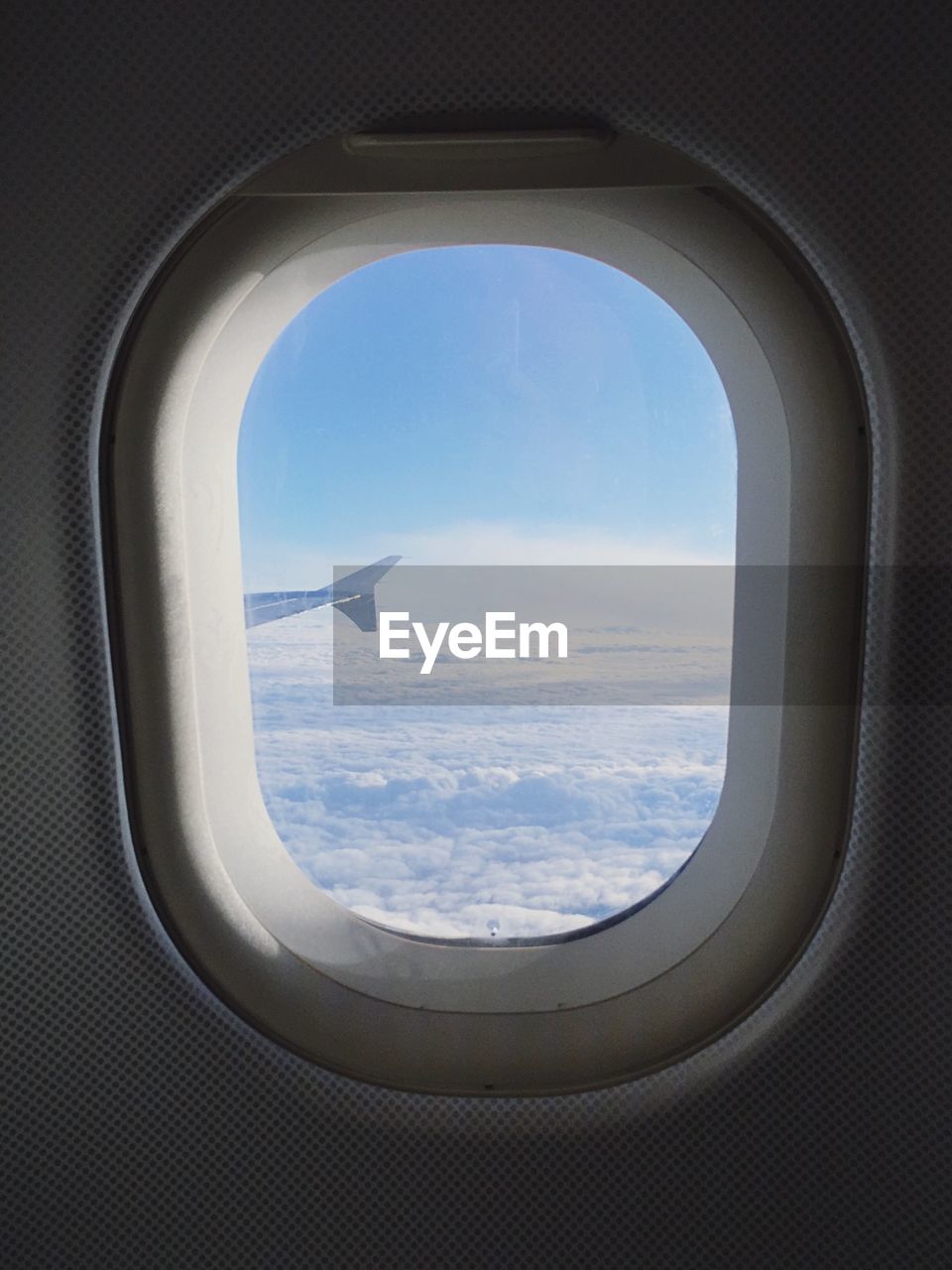 Cloudy sky seen through airplane window