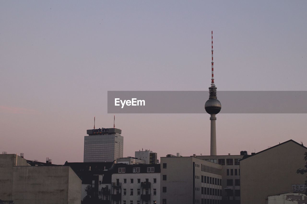 Fernsehturm amidst buildings against clear sky in city