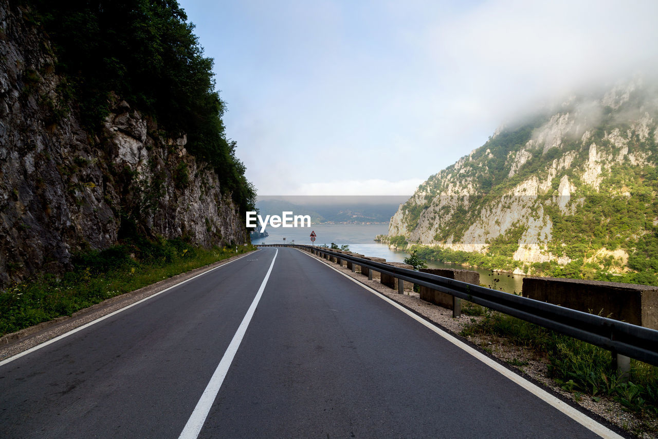 EMPTY ROAD LEADING TOWARDS MOUNTAINS