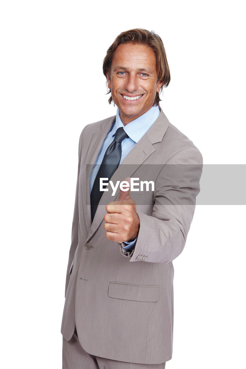 business, smiling, adult, businessman, men, formal wear, portrait, one person, looking at camera, white background, happiness, cut out, studio shot, clothing, finger, emotion, professional occupation, indoors, standing, cheerful, corporate business, success, business finance and industry, teeth, occupation, smile, white-collar worker, mature adult, sales occupation, person, tuxedo, positive emotion, tie, copy space, waist up, sales clerk, menswear, necktie, hand
