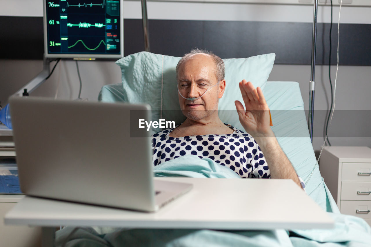 Midsection of man using mobile phone while sitting on table